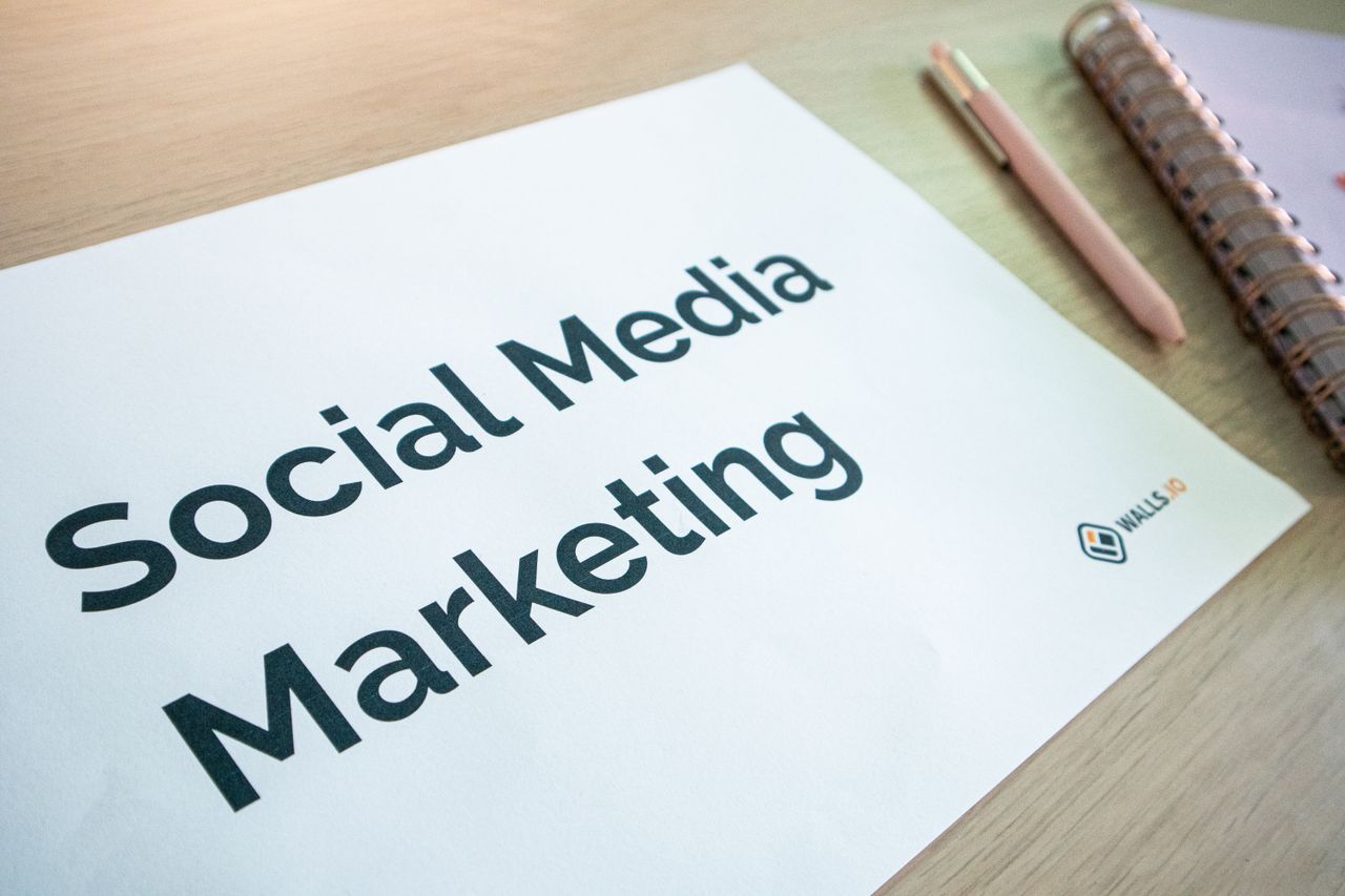 services-04 Close-up of a social media marketing document on a desk with a pen and notebook.